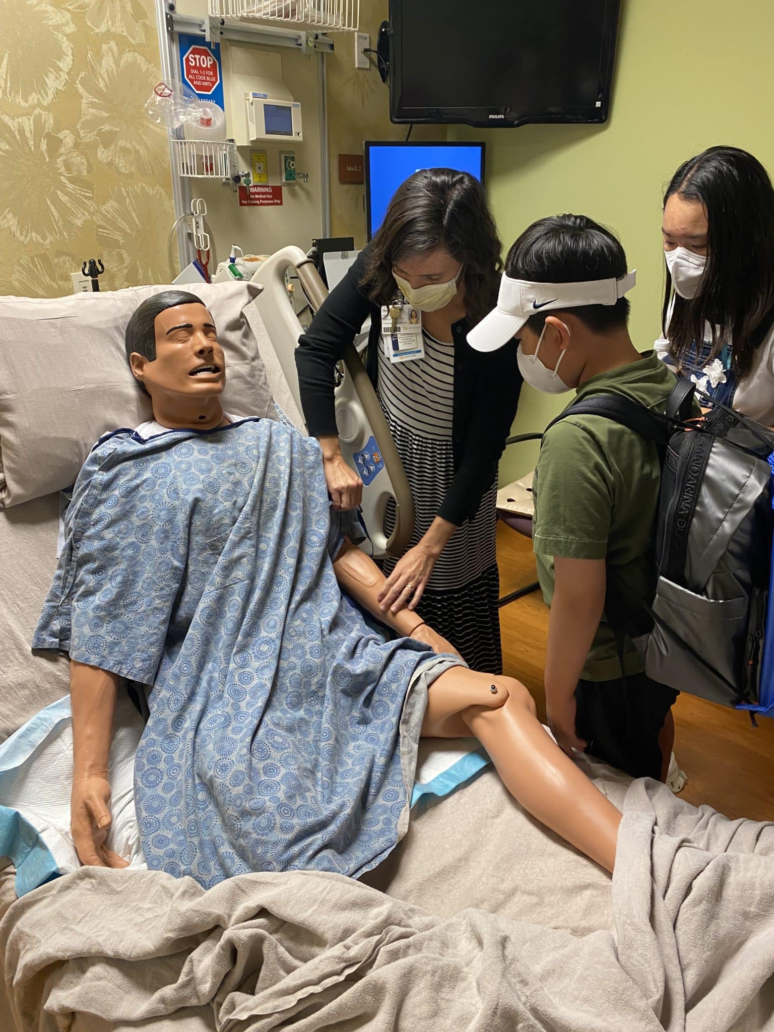 Nurse Mina teaches youth about caring for patients with a SIM-Man